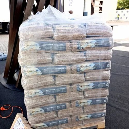Palet de Pellet CYL con 100 sacos de 15 kg, certificación Din Plus y bajo en cenizas, apilado en un entorno de almacenamiento.