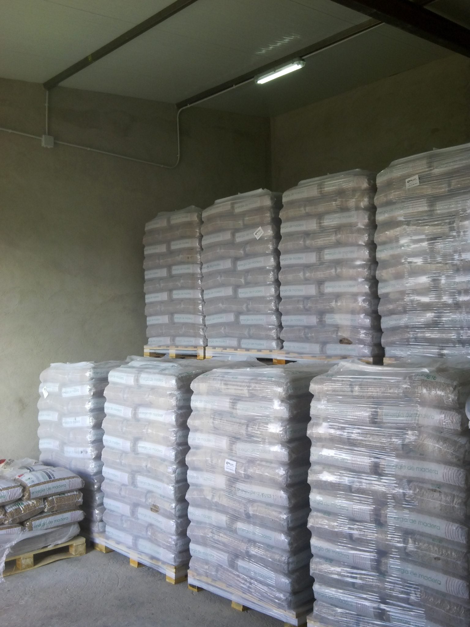 Palet de Pellet CYL con 100 sacos de 15 kg, certificado Din Plus y bajo en cenizas, en un entorno de almacenamiento.